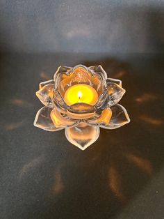 a glass candle holder sitting on top of a table