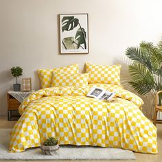 a yellow and white checkered comforter set in a room with potted plants