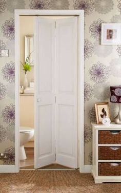 an open door leading to a bathroom with floral wallpaper