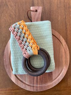 a crocheted ring is sitting on top of a napkin with a wooden holder