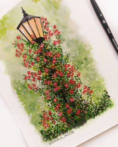 a watercolor painting of a lamp post with flowers in the foreground and a black pencil resting on it