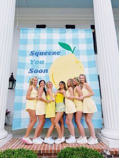 four girls in yellow dresses posing for the camera