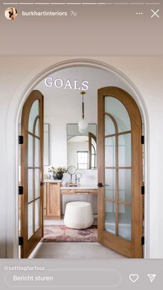 an arched doorway leading to a bathroom with a white stool and mirror on the wall