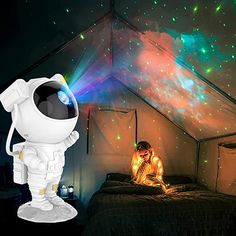 an astronaut is sitting on the bed in front of a projector that lights up