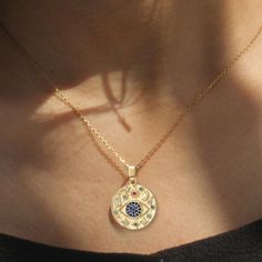 This exquisite Evil Eye Coin Pendant Necklace features a stunning gold-plated design crafted from durable stainless steel, ensuring both elegance and longevity. The centerpiece showcases a vibrant, colorful cubic zirconia stone that adds a touch of uniqueness and charm, making it a perfect accessory for any occasion. Ideal for those seeking to combine style with a protective symbol, this necklace is a must-have addition to your jewelry collection. Symbolic Evil Eye Pendant Jewelry, Evil Eye Round Pendant Jewelry For Good Luck, Metal Evil Eye Necklace With Round Shape, Gold Plated Evil Eye Amulet Jewelry, Gold-plated Evil Eye Amulet Necklace, Eye Pendant Necklace, Necklace Evil Eye, Pendant Necklace Gold, Coin Pendant Necklace