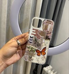 a person holding up a cell phone case with pictures and words on it, in front of a mirror