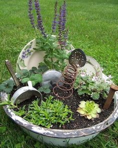 a potted planter filled with plants and gardening implements on top of green grass