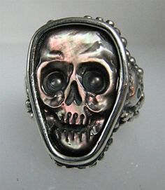 a silver ring with a skull on it's face and two eyes in the middle