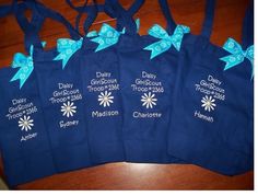 five bags with blue bows on them sitting on a table