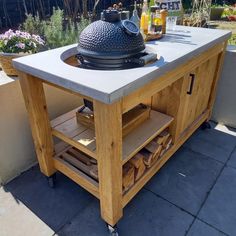 an outdoor bbq grill on top of a wooden table