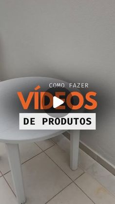 a white table sitting on top of a tiled floor next to a wall with the words video's de produtos