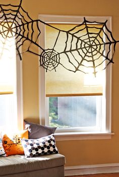 the window is decorated with spider webs and other decorations for halloween time, as well as an easy diy project