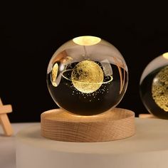 two glass globes sitting on top of a wooden stand