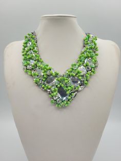 Each piece of our statement necklaces is handmade and one of a kind made in Italy. Our creations is made of high quality materials such as crystals and rhinestones. Each embroidered material is carefully hand sewn. Very glamorous and stylish. Perfect gift to someone you like. Materials Strass stone and Rhinestone in Crystal color and Green pistils in different dimension.  Black satin fabric backing. Aluminium chain with lobster closure. Measurements Weight approximate 200 grams. Chain lenght 25 cm - 9.84 in Circumference approximate 63 cm - 24.80 in Feel free to contact us if you have any question. Thank you so much for looking at our shop and our articles each of them, single piece. Green Crystal Necklaces With Sparkling Stones, Green Necklaces With Sparkling Stones For Party, Crystal Necklace With Sparkling Stones, Green Necklace With Sparkling Stones For Party, Green Sparkling Stone Necklace For Party, Crystal Beaded Necklaces With Rhinestones For Gifts, Silver Crystal Beaded Necklaces With Rhinestones, Jeweled Crystal Beaded Costume Necklace, Crystal Beaded Costume Jewelry Necklace