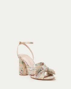 Heeled sandal in a pastel floral print on tan base fabric topped with our signature pleated bow. Padded footbed with gold stamped logo. Open toe with adjustable buckle ankle strap. 3.5 inch heel.