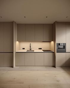 an empty kitchen with beige cabinets and black appliances in the center, is lit by recessed lighting