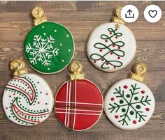 four decorated christmas ornament ornaments on top of a wooden table