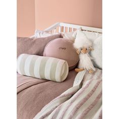 a stuffed animal sitting on top of a bed next to pillows and pillowcases