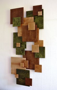 a wall sculpture made out of wood and green squares on the back of each piece