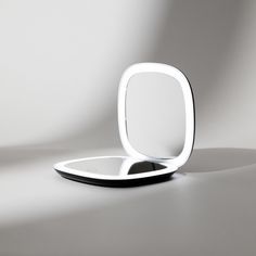 a mirror sitting on top of a table next to a white wall in the background