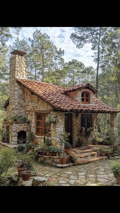 a small stone house surrounded by trees and plants