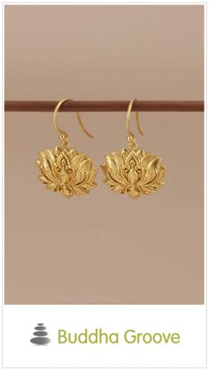 Gold lotus flower earrings, hanging on a display rod. Traditional Gold Flower Earrings With Ear Wire, Elegant Brass Earrings With Flower Charm, Elegant Lotus Flower Jewelry For Wedding, Gold Spiritual Drop Earrings, Traditional Gold Flower Earrings, Graceful Gold Dangle Earrings, Graceful Gold Earrings, Gold Teardrop Flower Charm Earrings, Gift Flower Earrings With Latkans