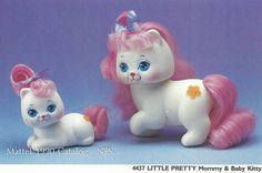 there are two small toys that look like cats and kittens, one is pink and the other is white