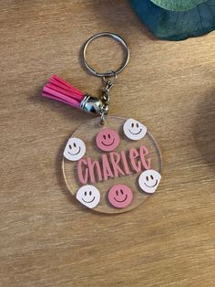 a keychain with some smiley faces on it and the word charge written in pink