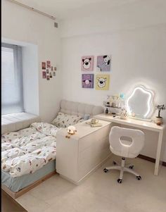 a bedroom with a bed, desk and mirror in it's corner next to a window