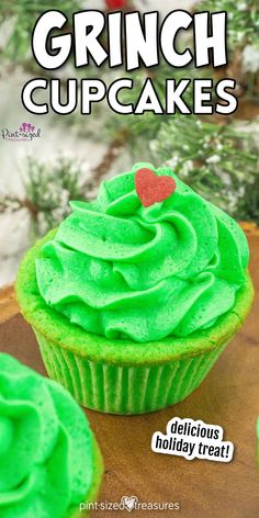 green cupcakes with frosting and a red heart on top are shown in front of a christmas tree