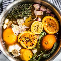 a pot filled with oranges and herbs