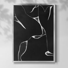 a black and white painting hanging on the wall