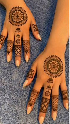 two hands with henna tattoos on them