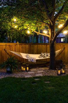 a hammock is lit up in the backyard at night