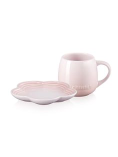 two pink cups and saucers sitting next to each other