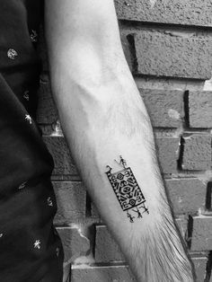 a black and white photo of a person's arm with a tattoo on it