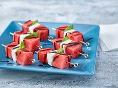 watermelon skewers with toothpicks and mint on a blue plate