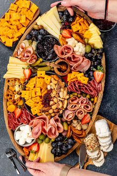 a platter filled with different types of cheeses, crackers and meats