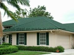 a white house with green shutters and palm trees