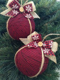 two red and white ornaments hanging from a christmas tree