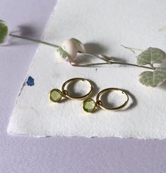 Gold peridot hoop earrings- 14k gold filled endless sleeper hoops - faceted gemstone charm - convertible earring - simple dainty gold hoop earring Simple 14k gold filled hoops with a removable gemstone charm. 2 styles for the price of one.  More gemstone available here: https://www.etsy.com/ca/listing/1027151649/gold-gemstone-hoop-earrings-14k-gold * SIZE: 14mm hoops with a 6mm stone  * MATERIAL: 14k gold filled, faceted gemstone set in gold plated sterling silver * SOLD IN PAIR Avoid contact wi Dainty Green Huggie Earrings As Gift, Dainty May Birthstone Hoop Earrings, Minimalist Gold Hoop Earrings With Birthstone, Gold Small Hoop Earrings For May Birthstone, Dainty Small Hoop Earrings With Birthstone, Gold Sleeper Earrings, Convertible Earrings, Ear Cuff Chain, Earring Simple