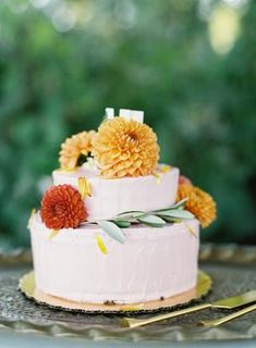 a three tiered cake with flowers on top