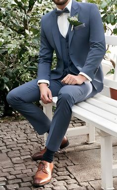 a man in a blue suit sitting on a white bench