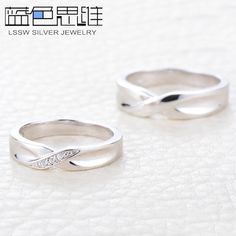 two silver rings sitting on top of a white surface