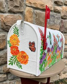 a white mailbox with flowers painted on it