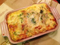 a casserole dish with cheese and broccoli in it on a table