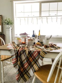 the table is covered with plaid cloths and plates, wine bottles, and fruit