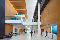 people are walking through the lobby of an office building