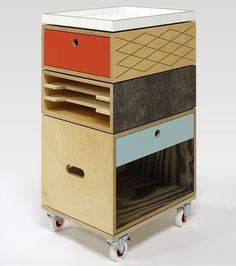 a multicolored wooden cart with drawers and wheels on the bottom, side by side