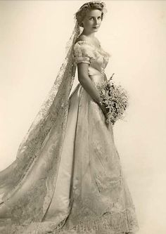 an old photo of a woman in a wedding dress with a veil on her head